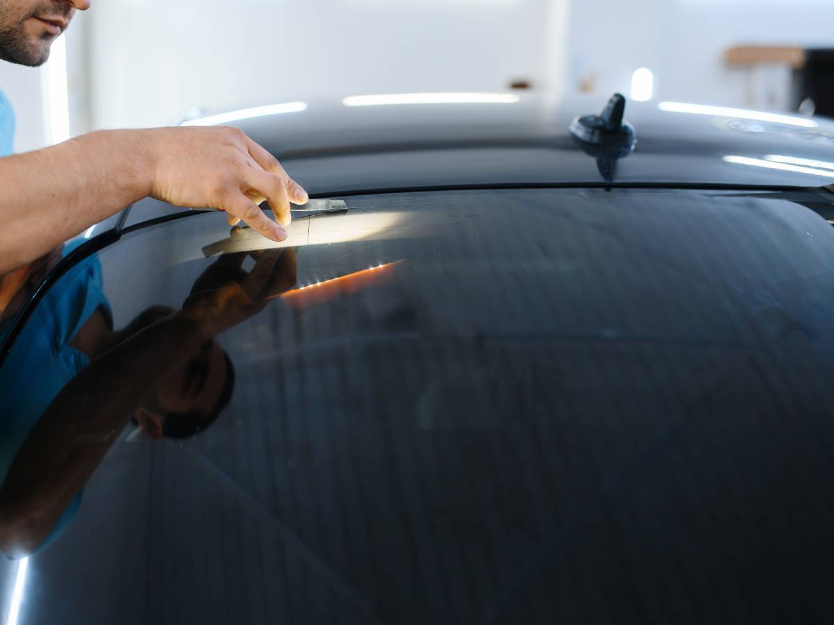 man installing window tinting film