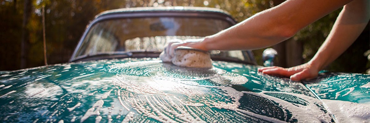 washing green car with sponge