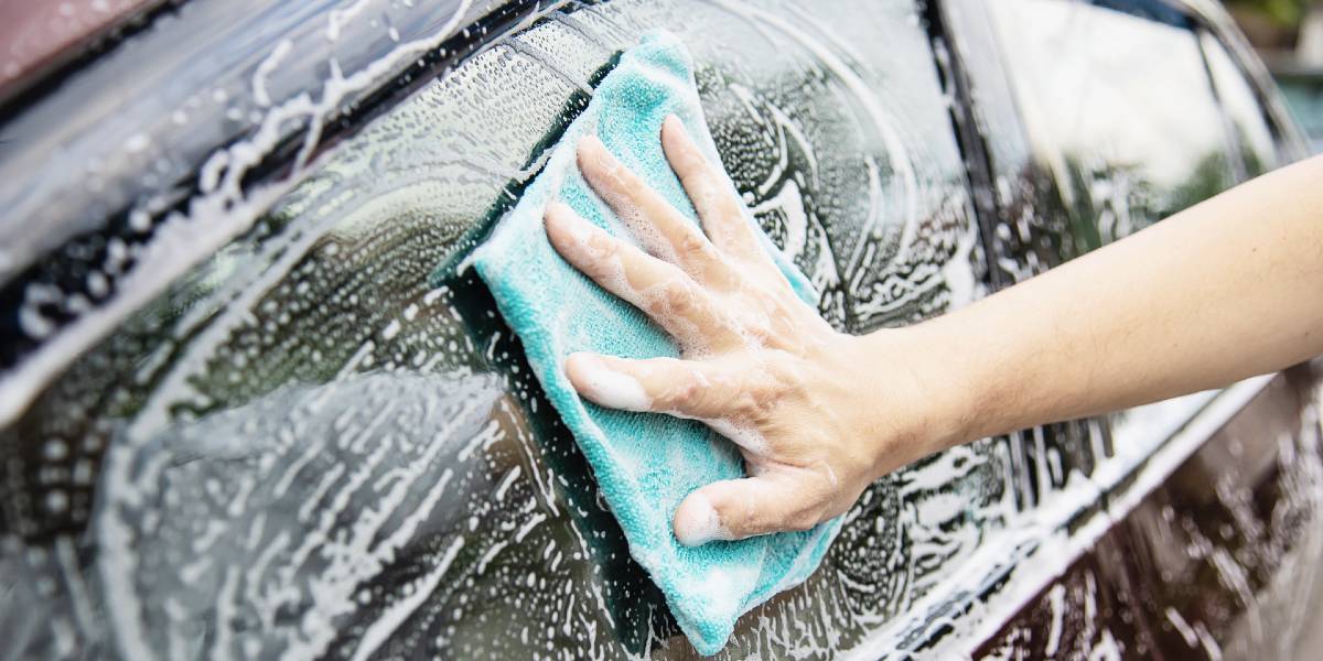man washing car using automotive soap
