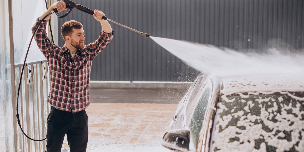 man washing his car with pressure washer