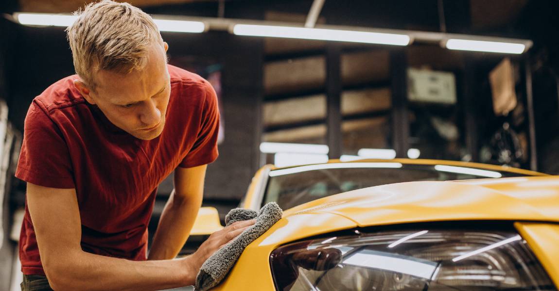 man wiping car after applying ceramic pro denver