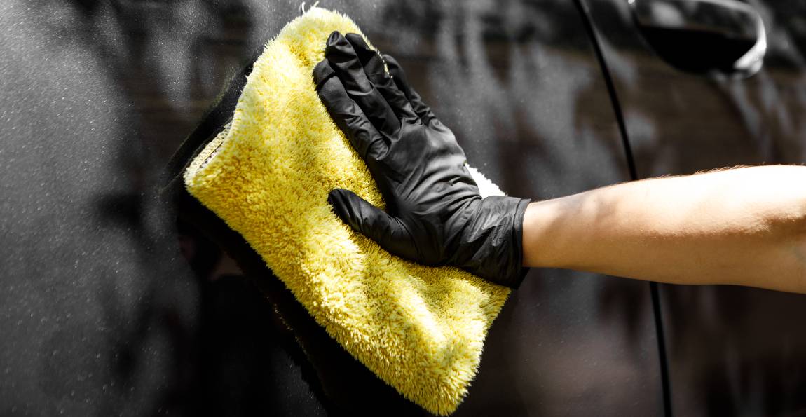 woman washing car with microfiber cloth