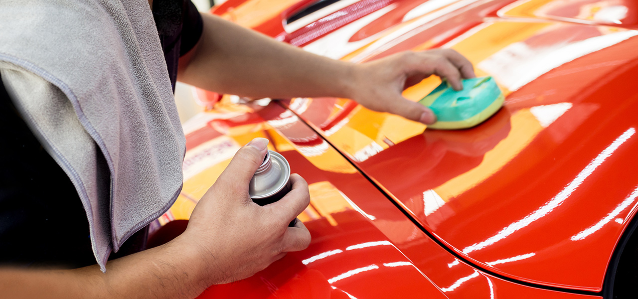 worker applying nano ceramic coating to sports car